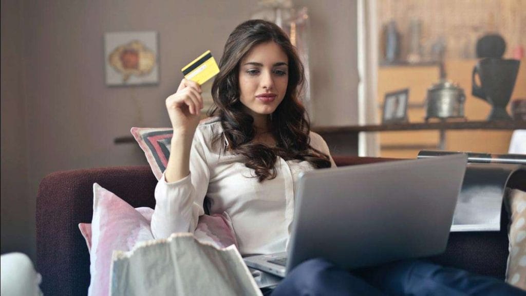 Mujer sosteniendo tarjeta de crédito con un Métodos de Pago en Amazon
