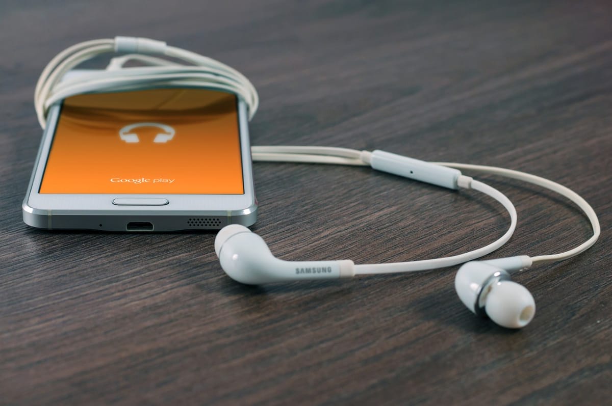 Teléfono celular con audífonos alámbricos reproduciendo música