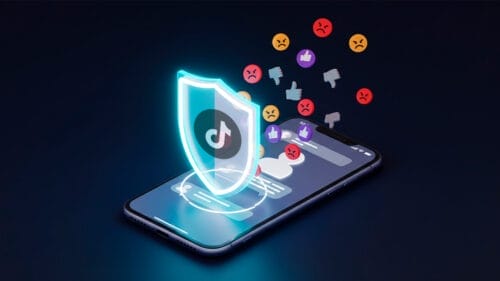 Imagen de un escudo, con el logo de TikTok, bloqueando emojis negativos, abajo un teléfono movil, haciendo referencia a que puedes bloquear a personas