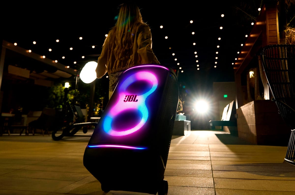 Fotografía de una mujer llevando la bocina con IA JBL PartyBox 520