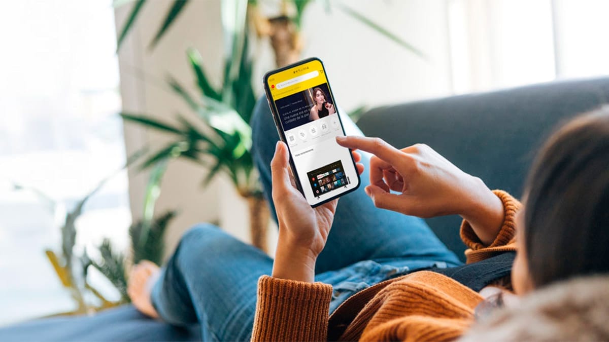 Mujer viendo su teléfono móvil, revisando la página de Unboxing Days de Mercado libre en busca de las mejores ofertas. Fuente: MercadoLibre